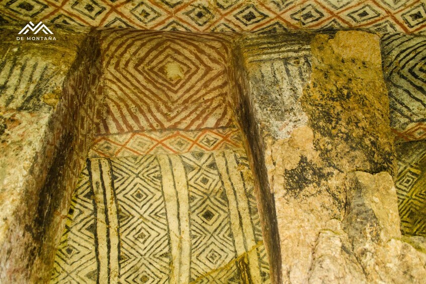Ancient cave wall paintings with geometric patterns and a central diamond-shaped design. 1