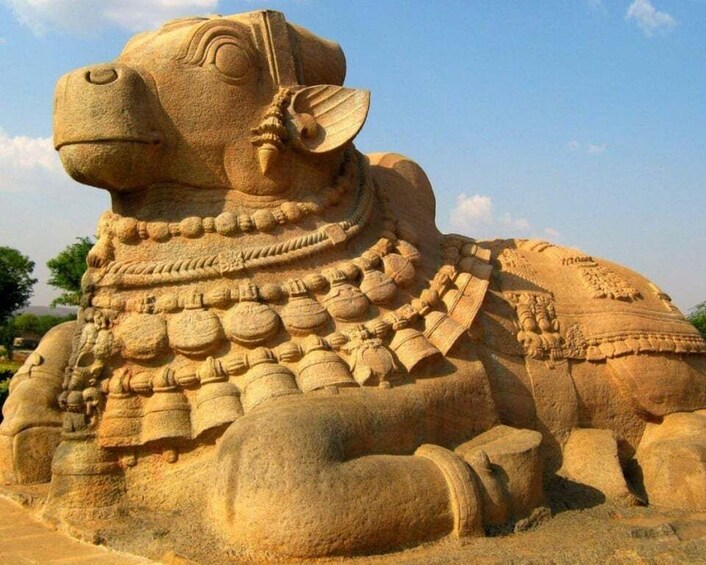 A large sandstone sculpture of a bull with intricate carvings and a headdress. 5
