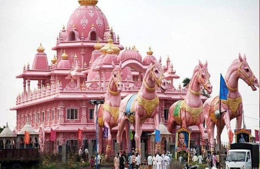 A pink temple with ornate architecture and large horse statues. 2