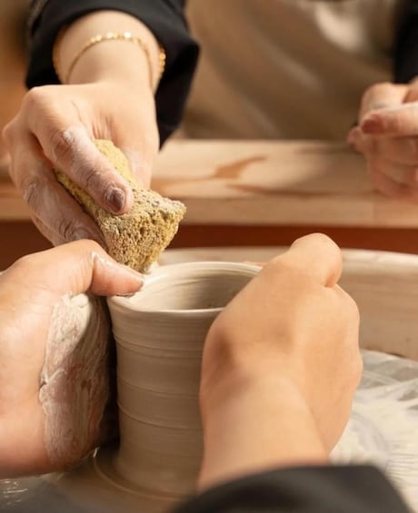 Hands shaping clay on a pottery wheel. 3