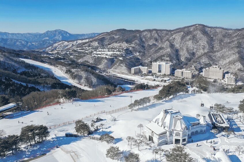 A snowy mountain landscape with ski slopes, buildings, and a church. 2