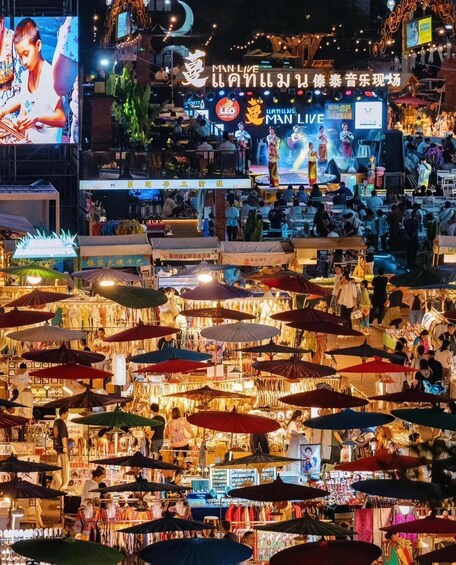 A bustling night market with numerous stalls and umbrellas. 2