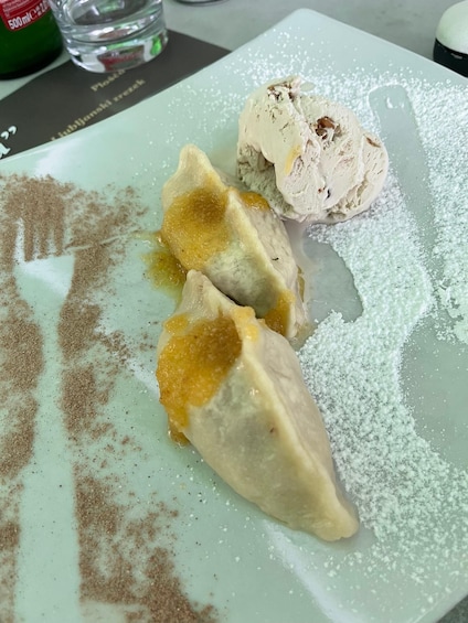 A plate with dumplings and a scoop of ice cream. 3