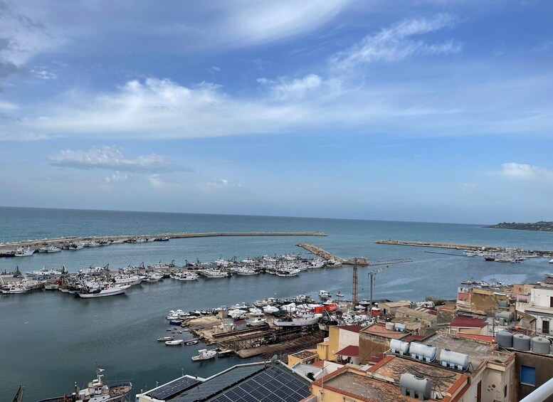 A harbor with numerous boats docked, a clear sky, and a distant shoreline. 5