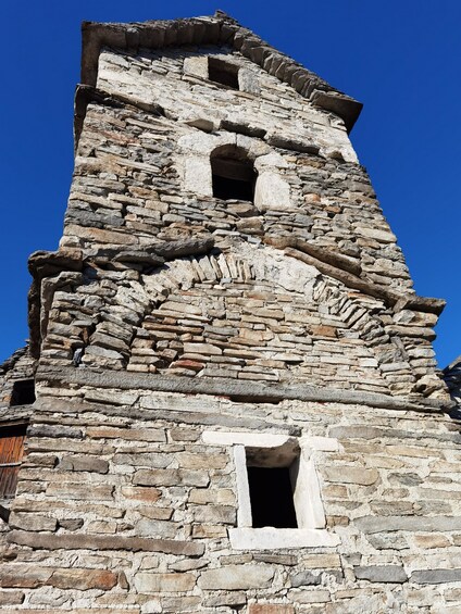 A stone tower with a small window and a door. 2