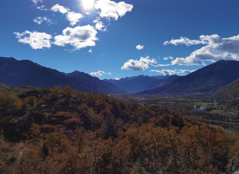 A mountainous landscape with autumn foliage, a valley, and a clear sky with clouds. 3
