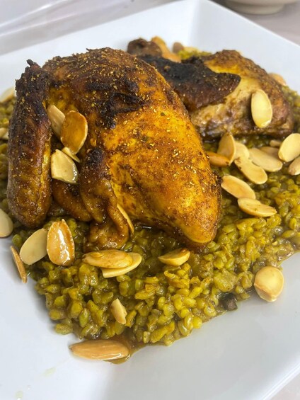 A plate of roasted chicken with almonds and a green lentil dish. 3