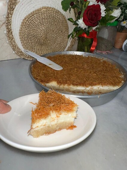A slice of a layered dessert on a plate, with a whole pie in the background. 5