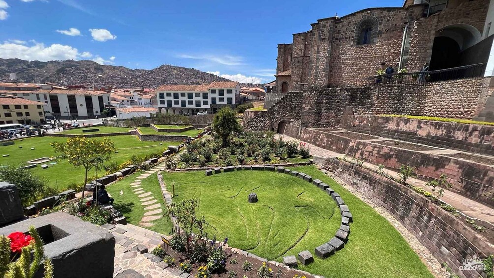 A historic stone building with a circular courtyard and a modern building in the background. 3