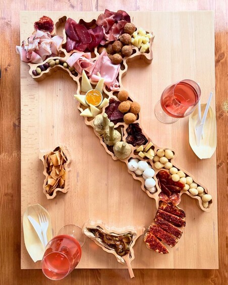 A charcuterie board with various meats, cheeses, and olives arranged on a wooden board. 1