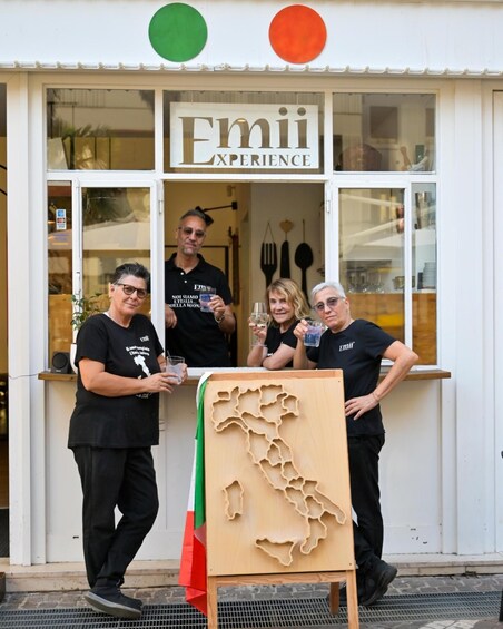 A storefront with the sign 'Emii Experience' and a wooden map of Italy. 2