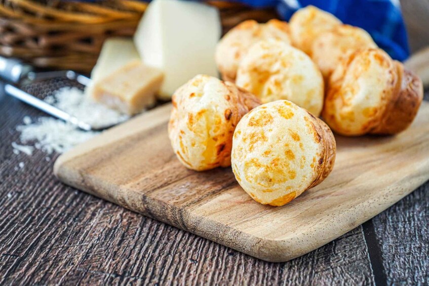 Une planche à découper en bois, avec plusieurs boules de fromage et un morceau de fromage en arrière-plan. 5