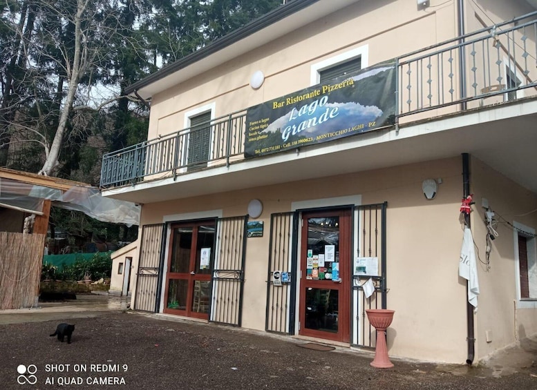 A building with a sign for a pizzeria named 'Lago Grande.' 3
