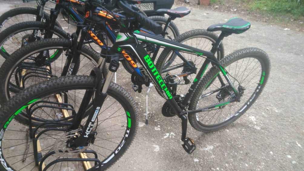 A mountain bike with green and black colors, a black seat, and a rear rack. 4