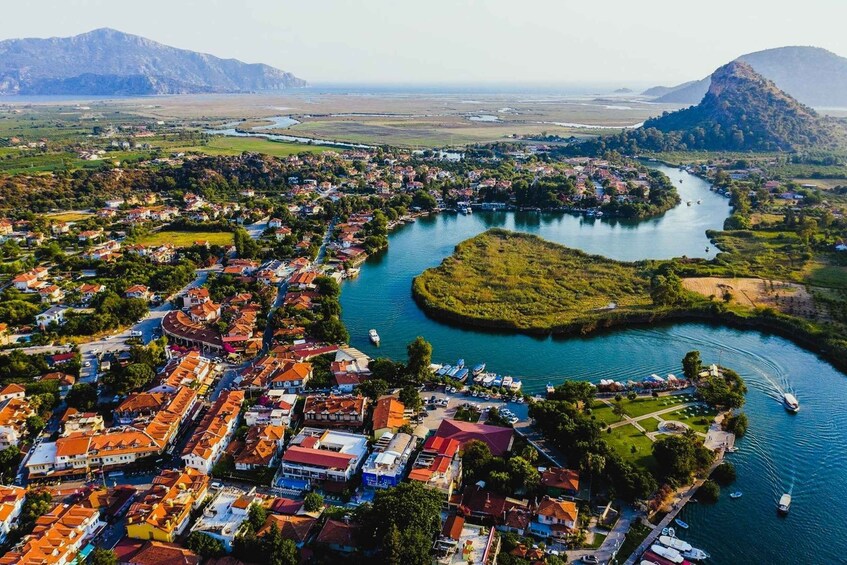 A coastal town with a river, boats, and mountains in the background. 4