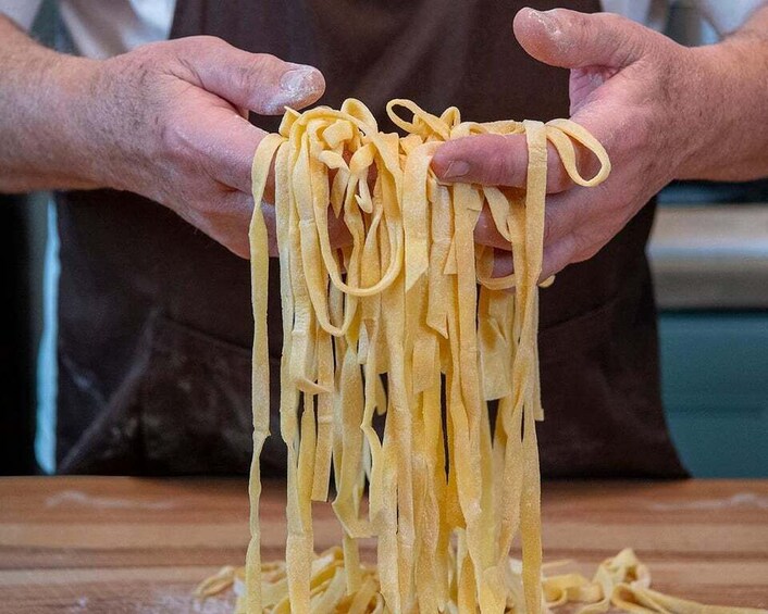 A person holding a bundle of pasta. 5