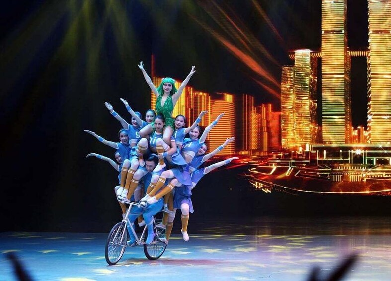 A group of people on a stage with a city skyline in the background. 1
