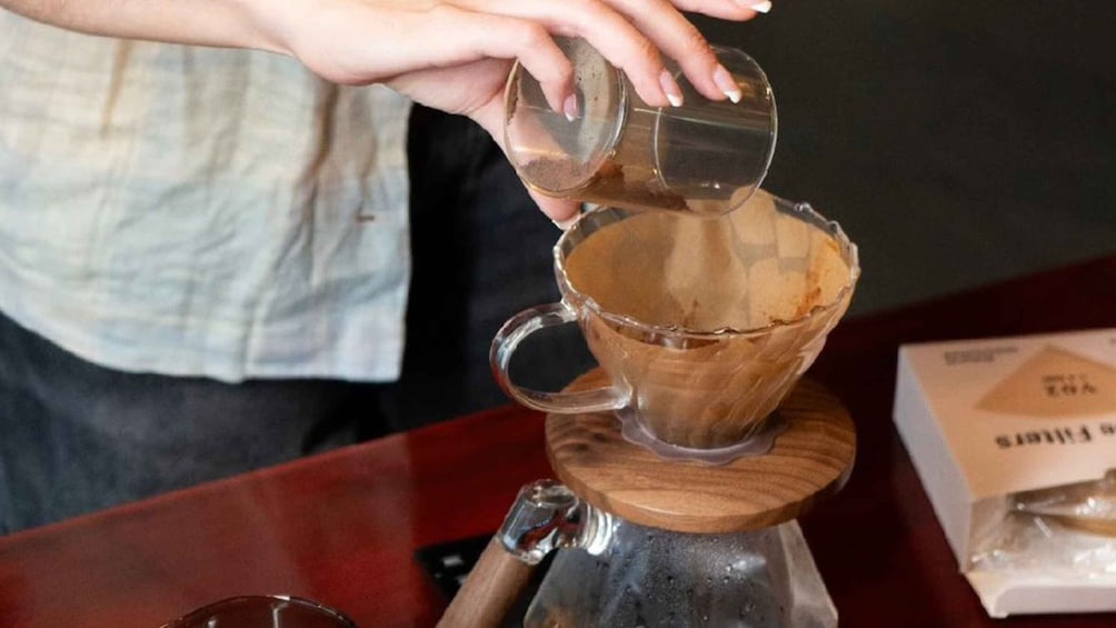 A person pouring a liquid into a glass. 2