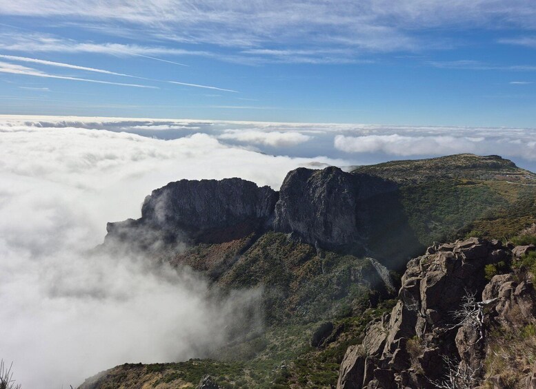 A mountainous landscape with a cloud-covered valley and a clear sky. 1