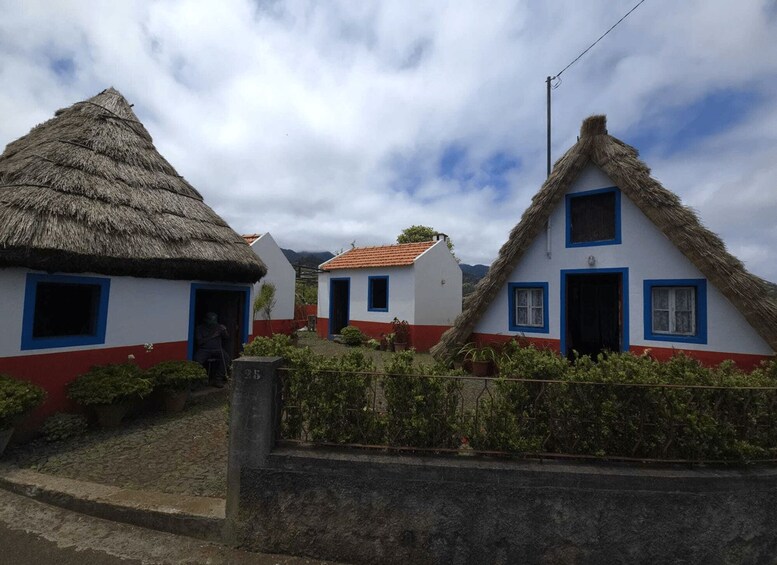 Traditional houses with thatched roofs and white walls with blue trim. 4