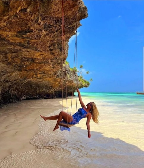 A woman swinging on a swing attached to a cliff by ropes. 5