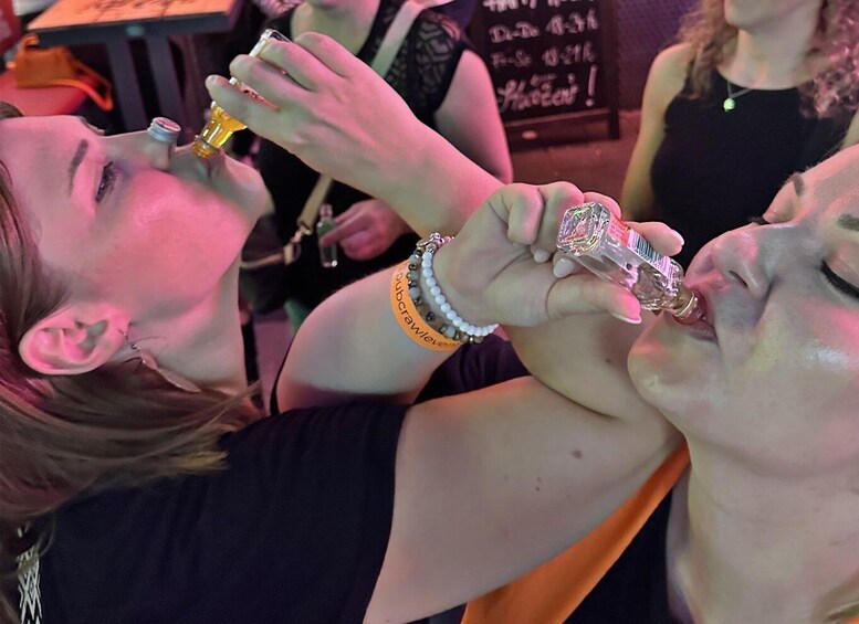 Two people holding and drinking from a bottle. 3
