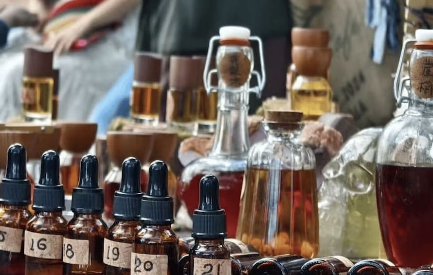 Various bottles of liquids with labels, some with droppers, and a glass container with a cork. 1