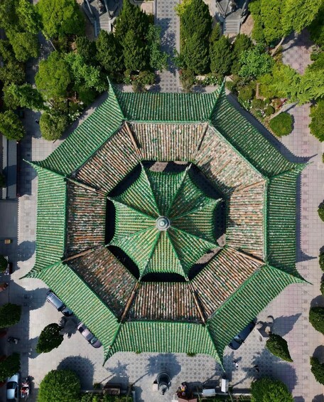A large, green, octagonal pavilion with a central circular area surrounded by a patterned floor. 5