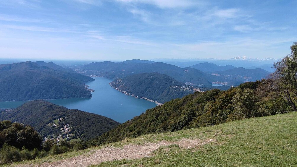 A mountainous landscape with a lake, forested hills, and a clear sky. 3