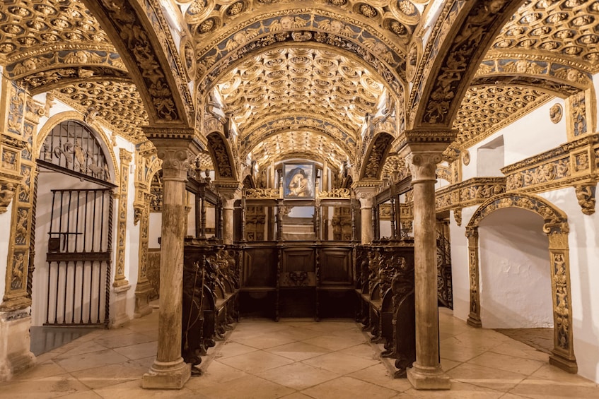 An ornate church interior with intricate gold detailing, arched ceilings, and a central altar. 3