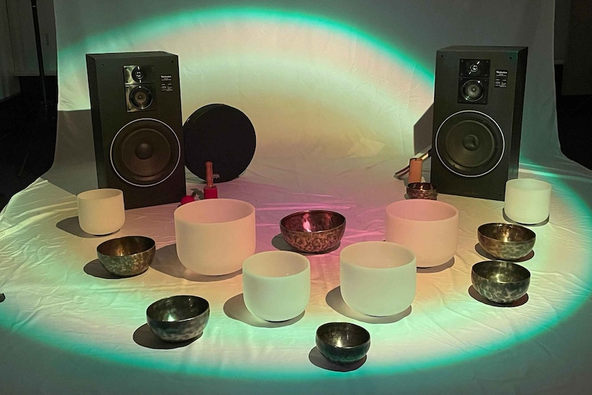 A table with speakers, bowls, and cups arranged in a circle. 2