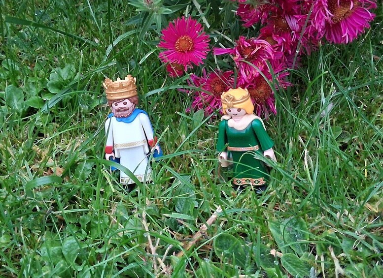 Two LEGO figures in a grassy field with pink flowers. 1
