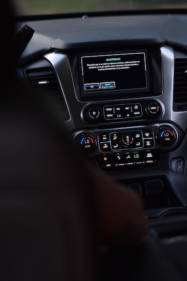 A car's dashboard with a warning message in Spanish about driving distractions. 1