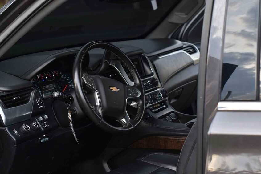 A car's interior with a steering wheel, dashboard, and gear shift. 4