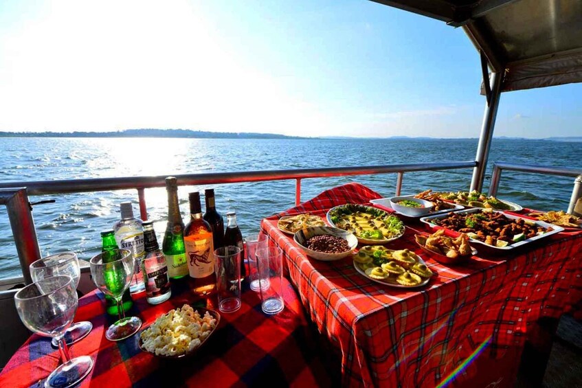 A table with food and drinks on a boat with a view of the water. 2