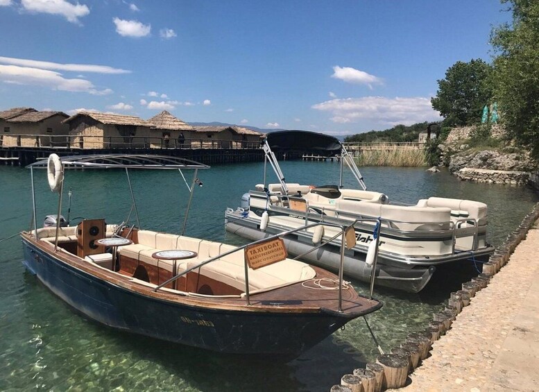 A boat docked at a pier with a clear sky and a distant mountain range. 2
