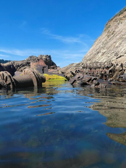 A rocky shoreline with clear water reflecting the sky. 3