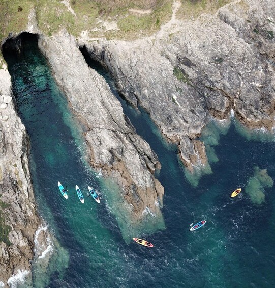 Kayakers navigating a narrow waterway between rocky cliffs. 4