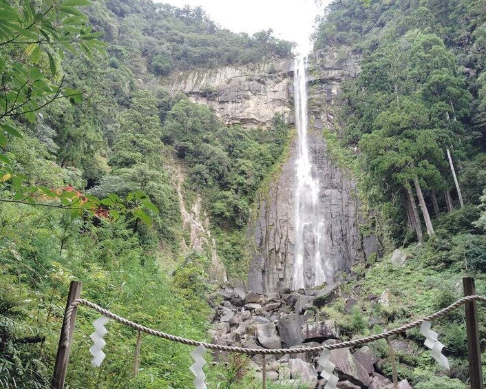A waterfall surrounded by dense forest and rocky terrain. 2