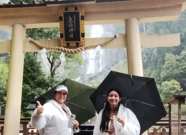 Two people under a pavilion with a waterfall in the background. 3