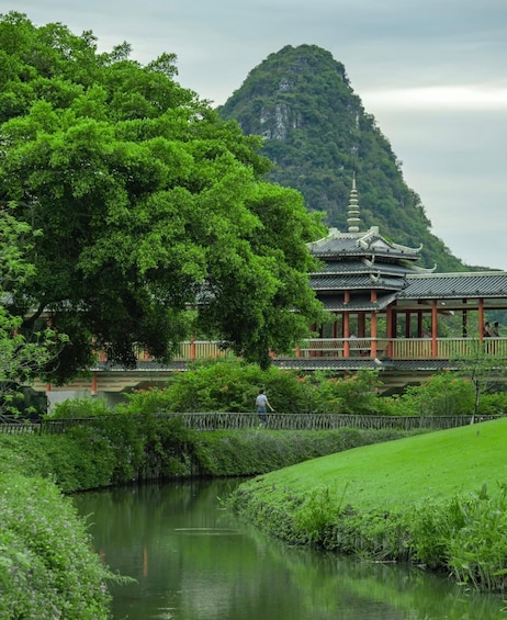 A traditional temple with a pagoda-style roof, surrounded by lush greenery and a calm pond. 4
