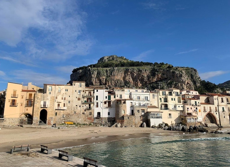 A coastal town with buildings, a cliff, and a beach. 3