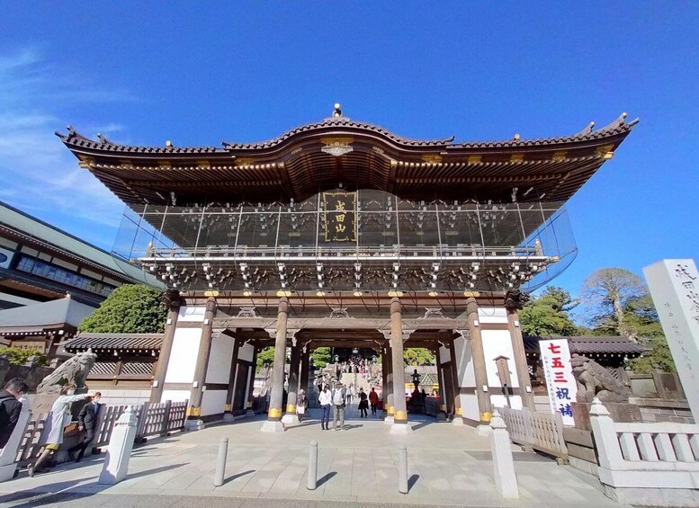 A traditional Japanese gate with a curved roof and intricate wooden carvings. 2