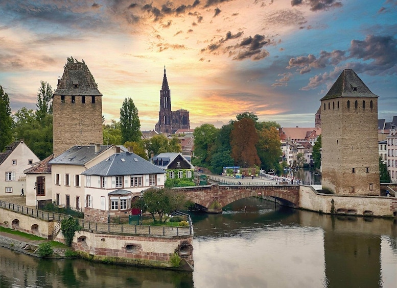 A historic cityscape with a river, two prominent towers, and a cathedral in the background. 5