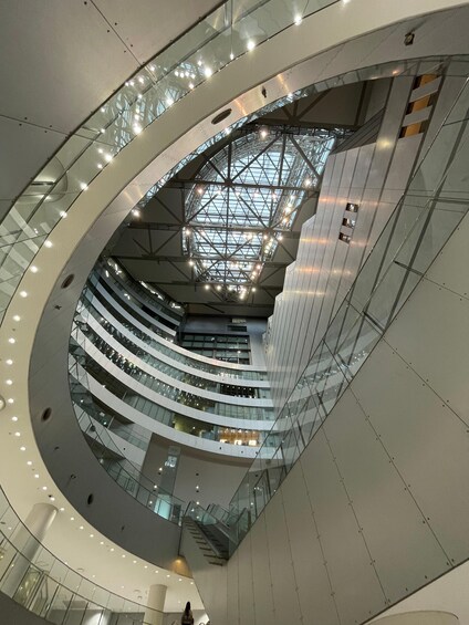 A modern multi-level atrium with glass railings and a skylight. 5