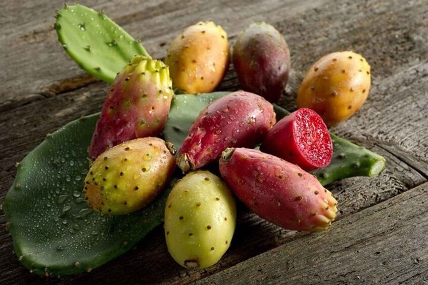A variety of prickly pear cactus fruits on a wooden surface. 5