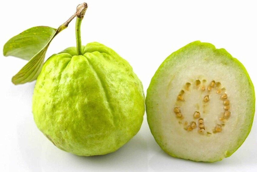 A guava fruit with a green exterior and a white interior with seeds. 4