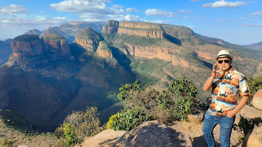 A person standing on a rocky outcrop with a canyon in the background. 3