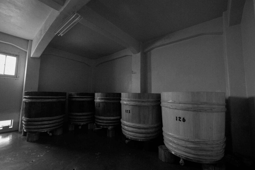 A storage area with wooden barrels labeled 123 and 126. 1
