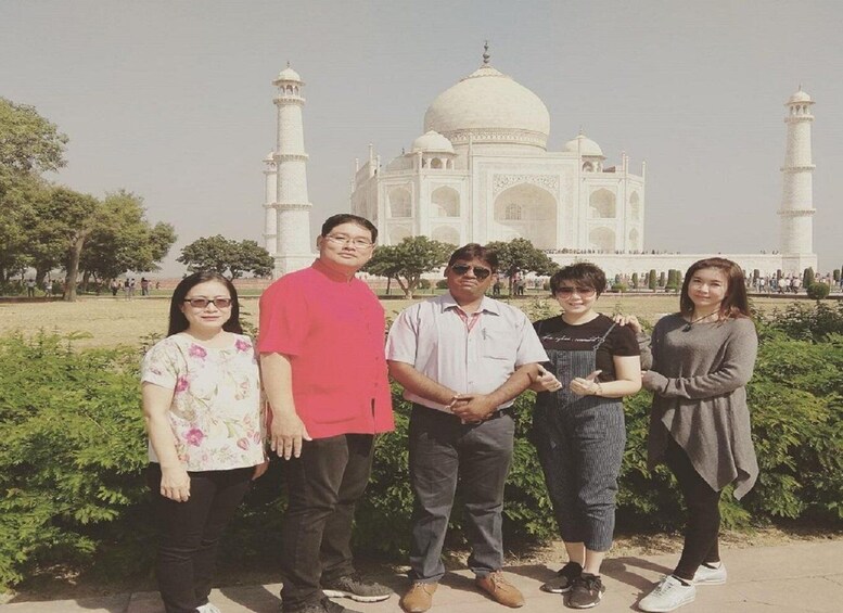 A group of people standing in front of the Taj Mahal. 1